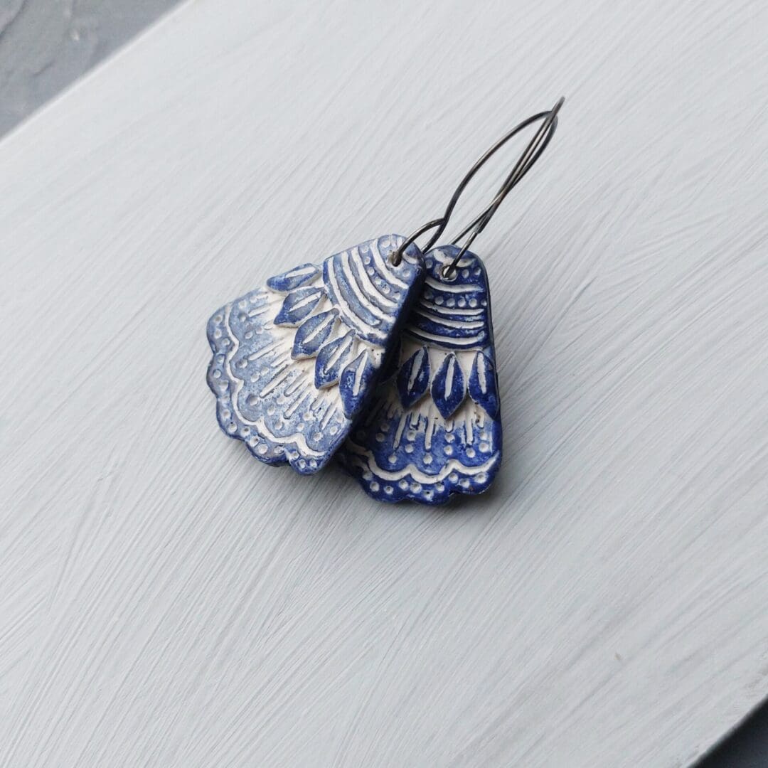 A pair of large blue and white pottery style polymer clay earrings by Weaversfield Jewellery