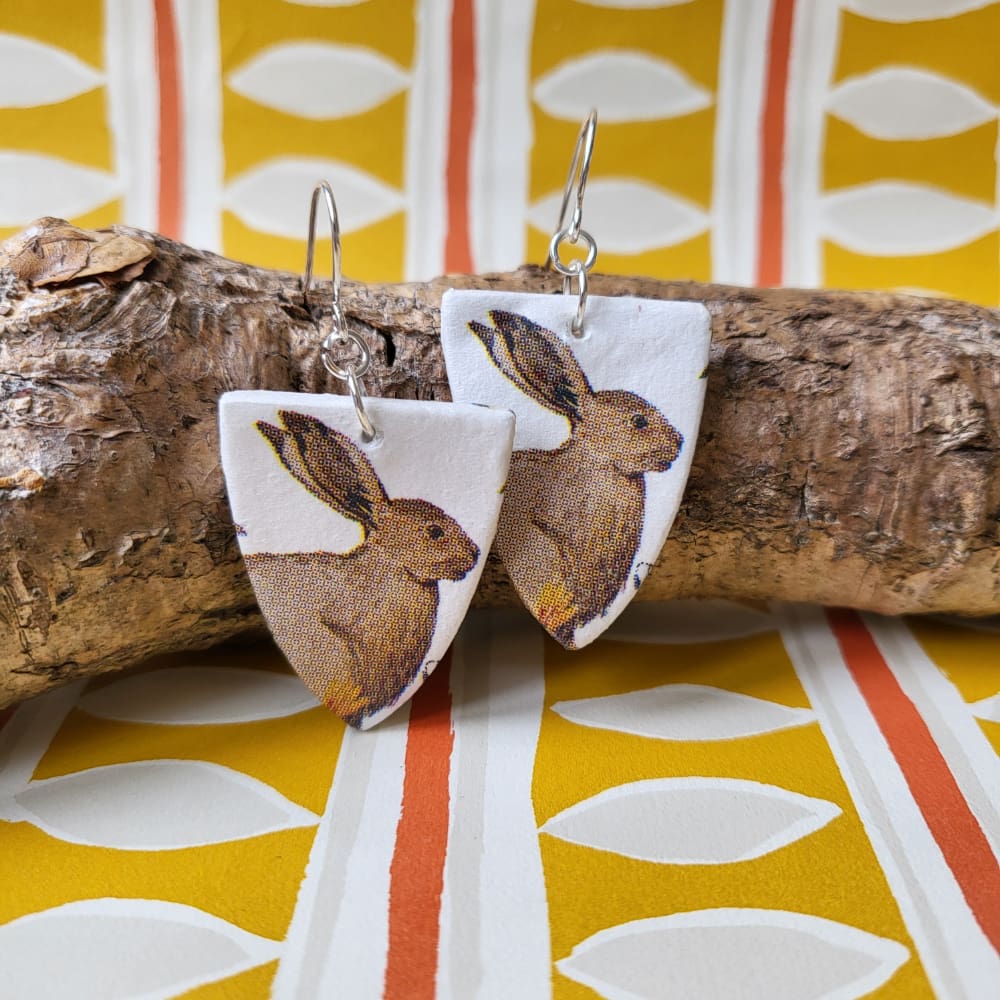 Arch shaped dangly earrings featuring a country hare pattern