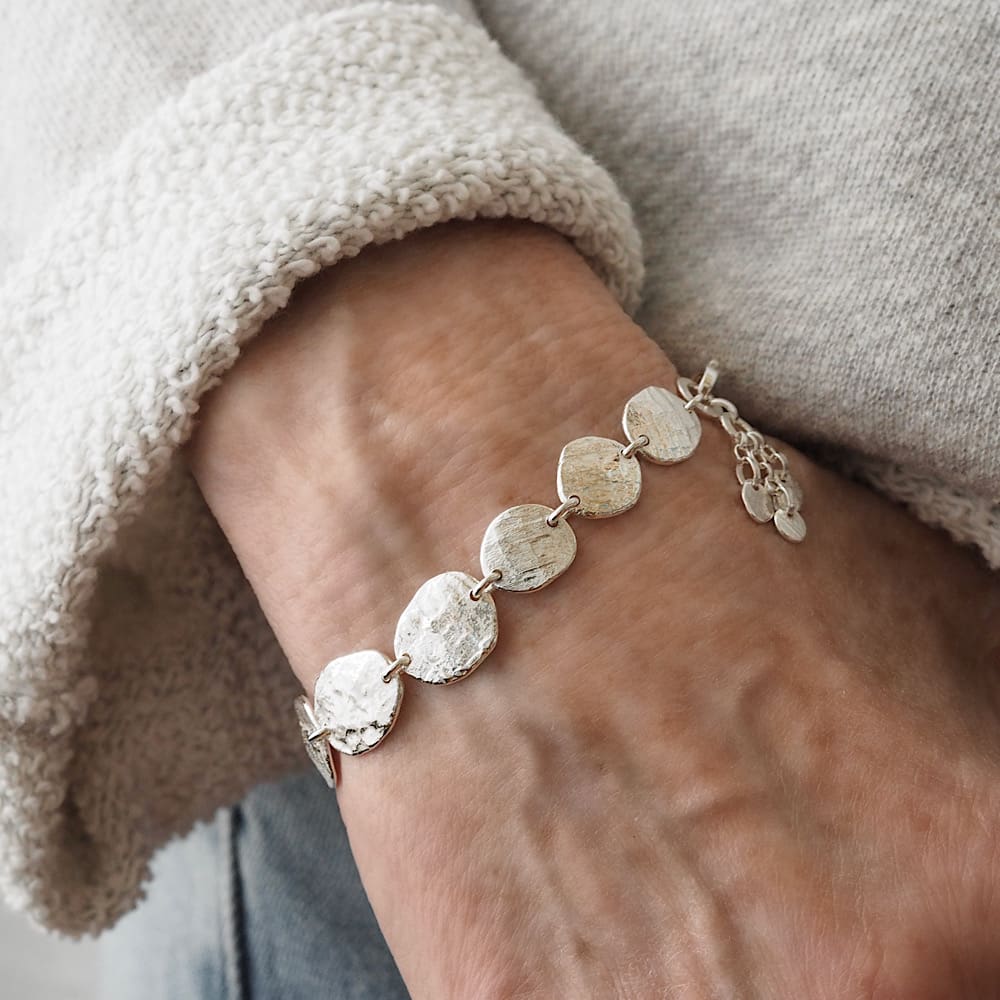 Handforged molten sterling silver disc bracelet. Discs resemble are irregular in shape and resemble stepping stones with a slate surface texture