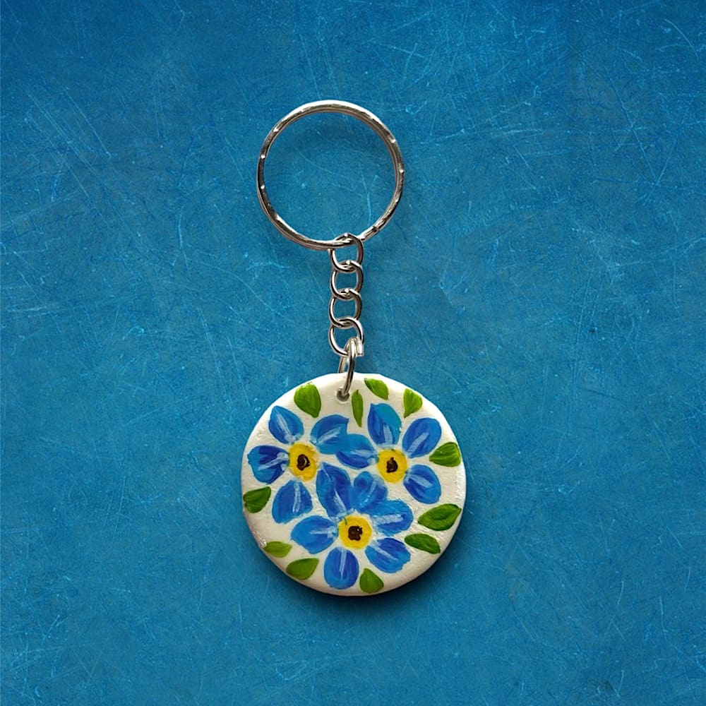 Handmade forget me not flower keyring. Small circular wooden keyring with three hand painted forget me not flowers.