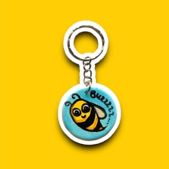 Handmade bee keyring with a blue background. Fun bumblebee design with the word "buzz".