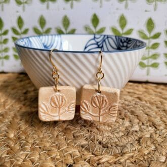 Square dangly earrings imprinted with a seedhead pattern