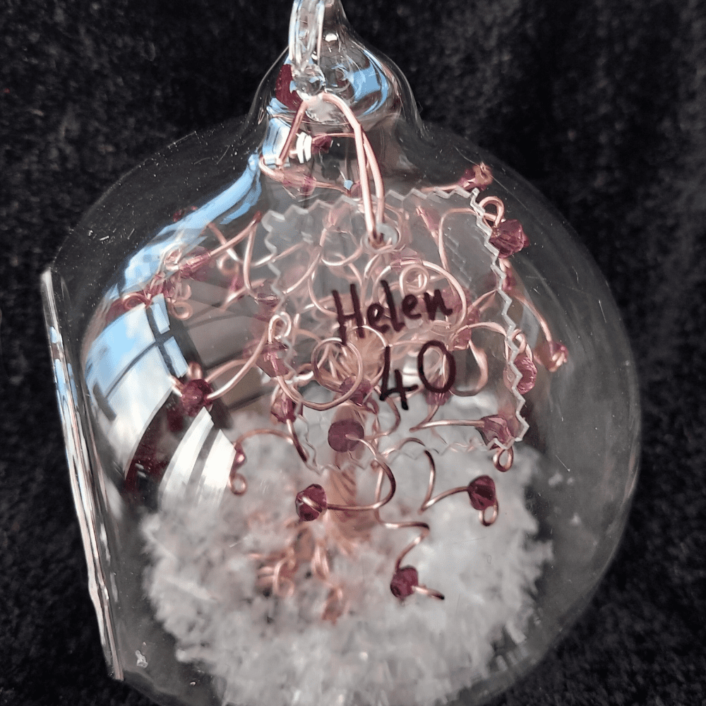 8cm glass bauble with a acrylic plaque that has a handwritten name in black ink. The clear acrylic is molded into the side of the bauble & wired onto it with rose gold wire.
