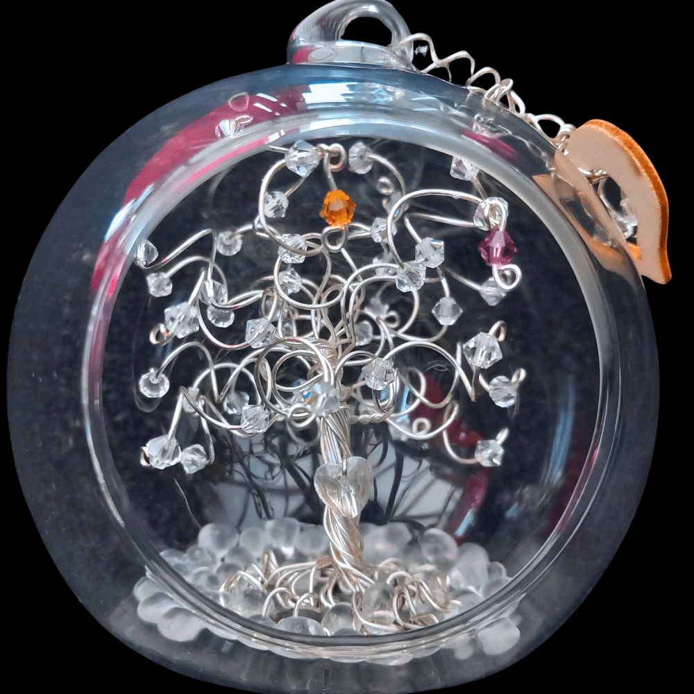 8cm glass open fronted bauble with a silver wire tree set into it on a glass bauble base. There is a clear crystal heart wired into the trunk and the branches are decorated with clear crystals, plus birthstone drops in topaz and amethyst.