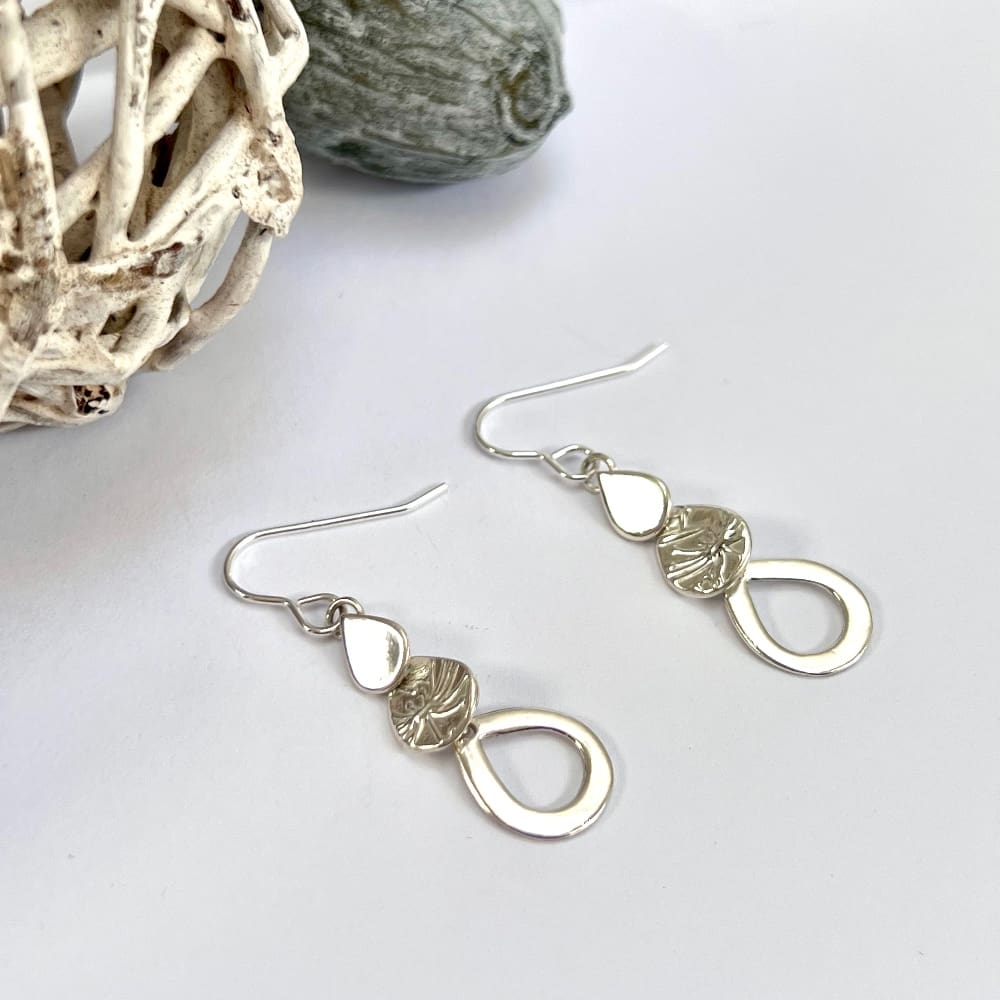 Silver teardrop dangle earrings. Three overlapping teardrops descending in size