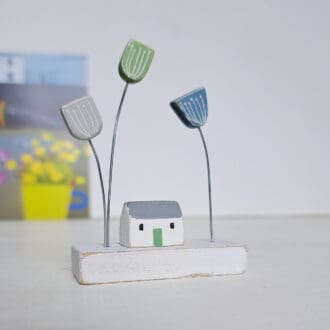 Scandi style ornament with a tiny white house with wooden blue and green flowers