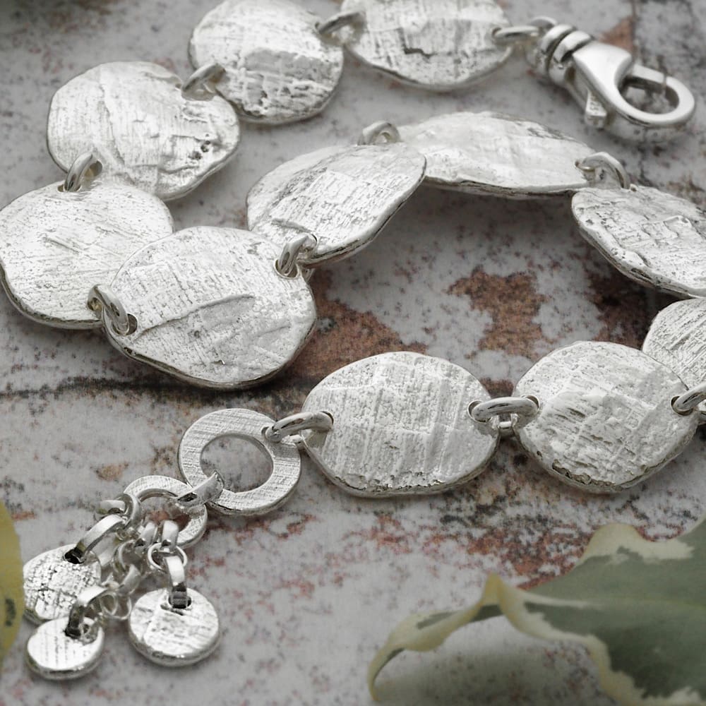 Unique sterling silver stepping stone disc bracelet. Each textured disc is individually hand forged with the impression of the charcoal block used in the process, each one a little irregular in shape