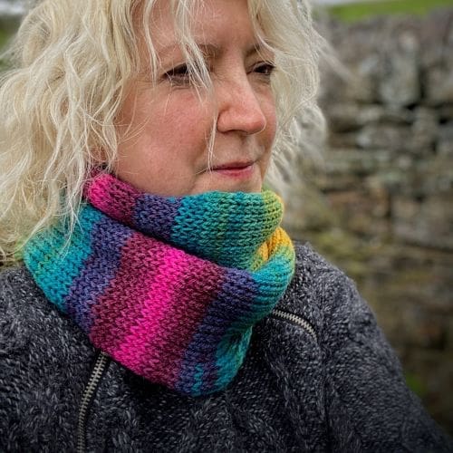 Knitted vegan infinity loop scarf in bright shades of pinks blues greens and golds