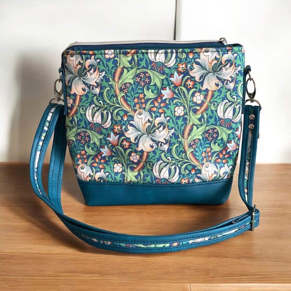 back view of ladies crossbody bag using William Morris style fabric with teal faux leather trims