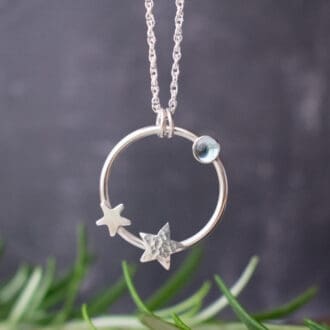 silver circle pendant with stars and topaz stone