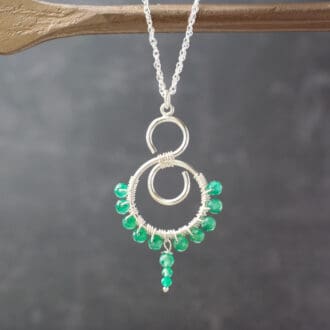 silver swirl necklace with green onyx beads wrapped around