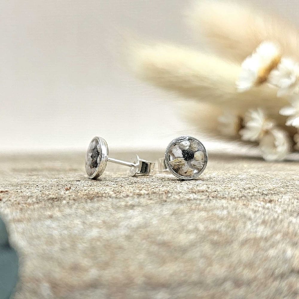 Pair of handcrafted remembrance 925 sterling silver round studs displayed on flat neutral stone