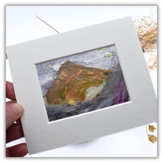 A mounted small painting of a mountain