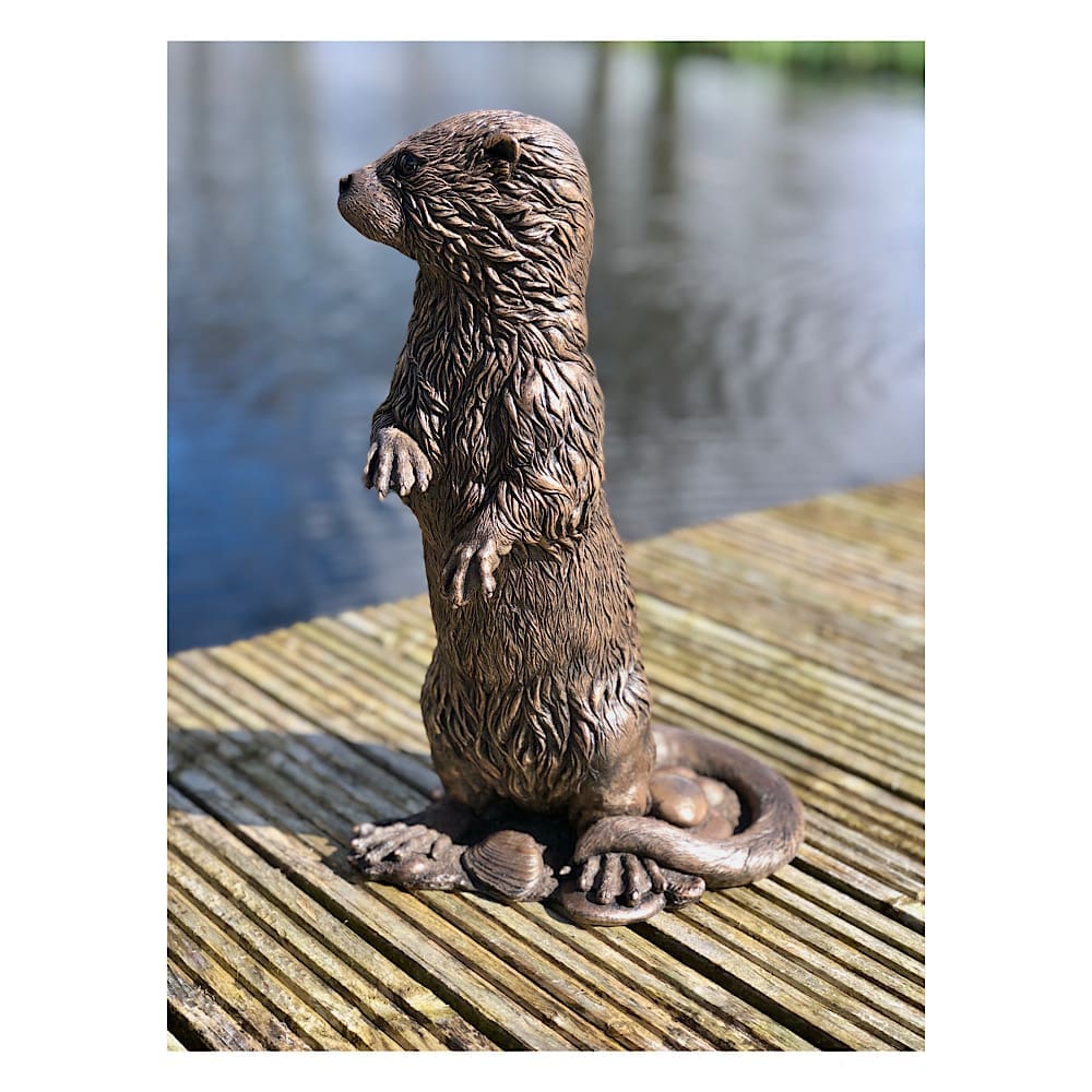 Large Otter sculpture in cold-cast bronze next to a lake