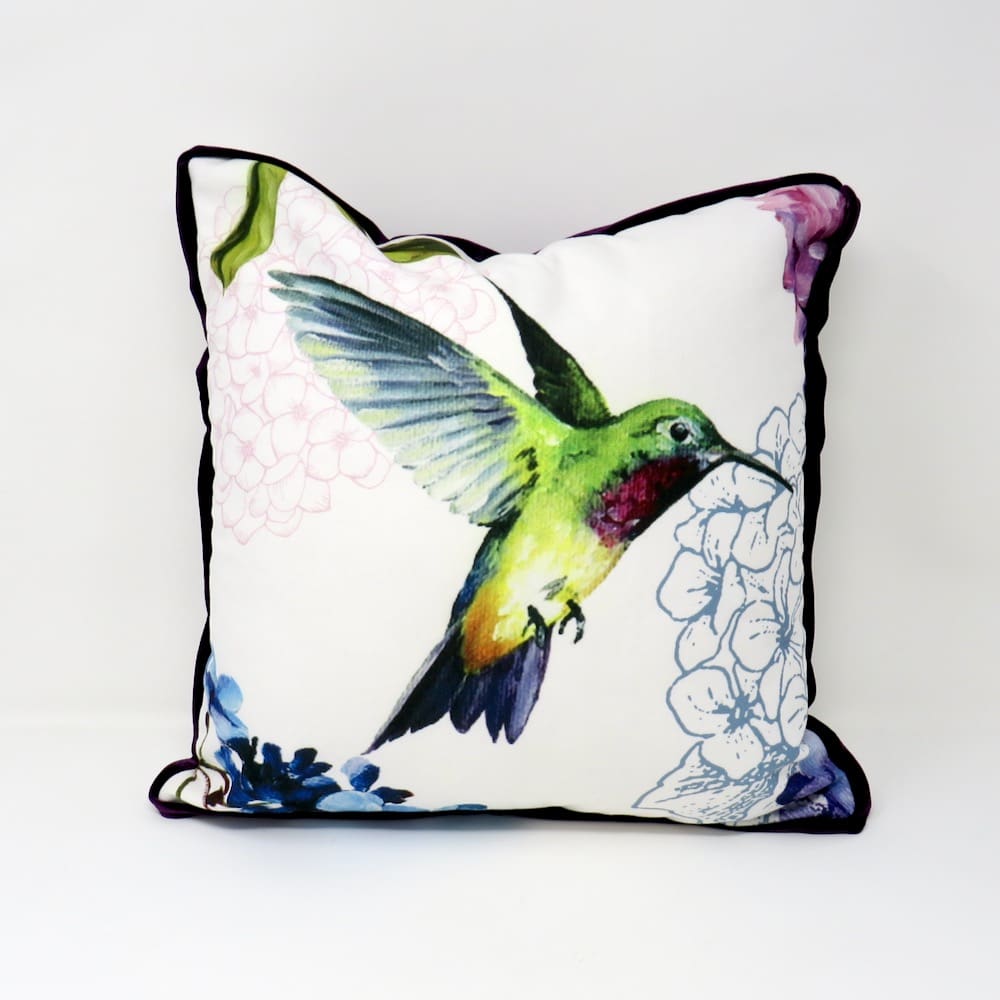 A printed velvet cushion with a bird motif and a purple velvet trim.