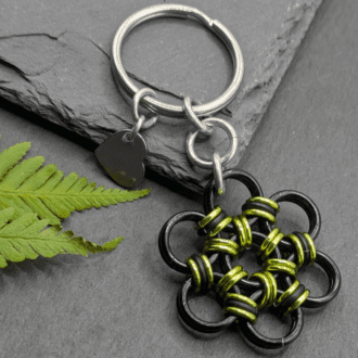 A keyring made into the shape of a flower. Made with larger black rings and smaller lime and black rings