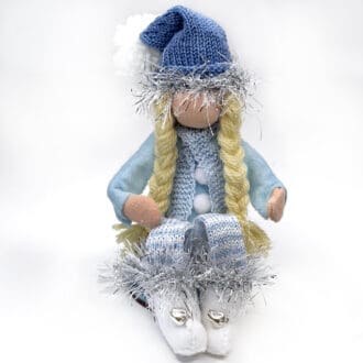 Girl Christmas gnome with blonde plaits sitting with knees up.