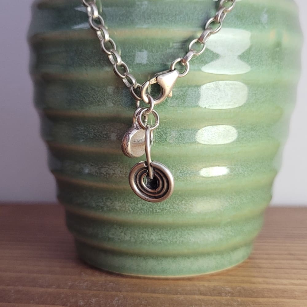 Sterling silver belcher chain bracelet with a charm inspired by ancient rock art known as cup and ring marks.