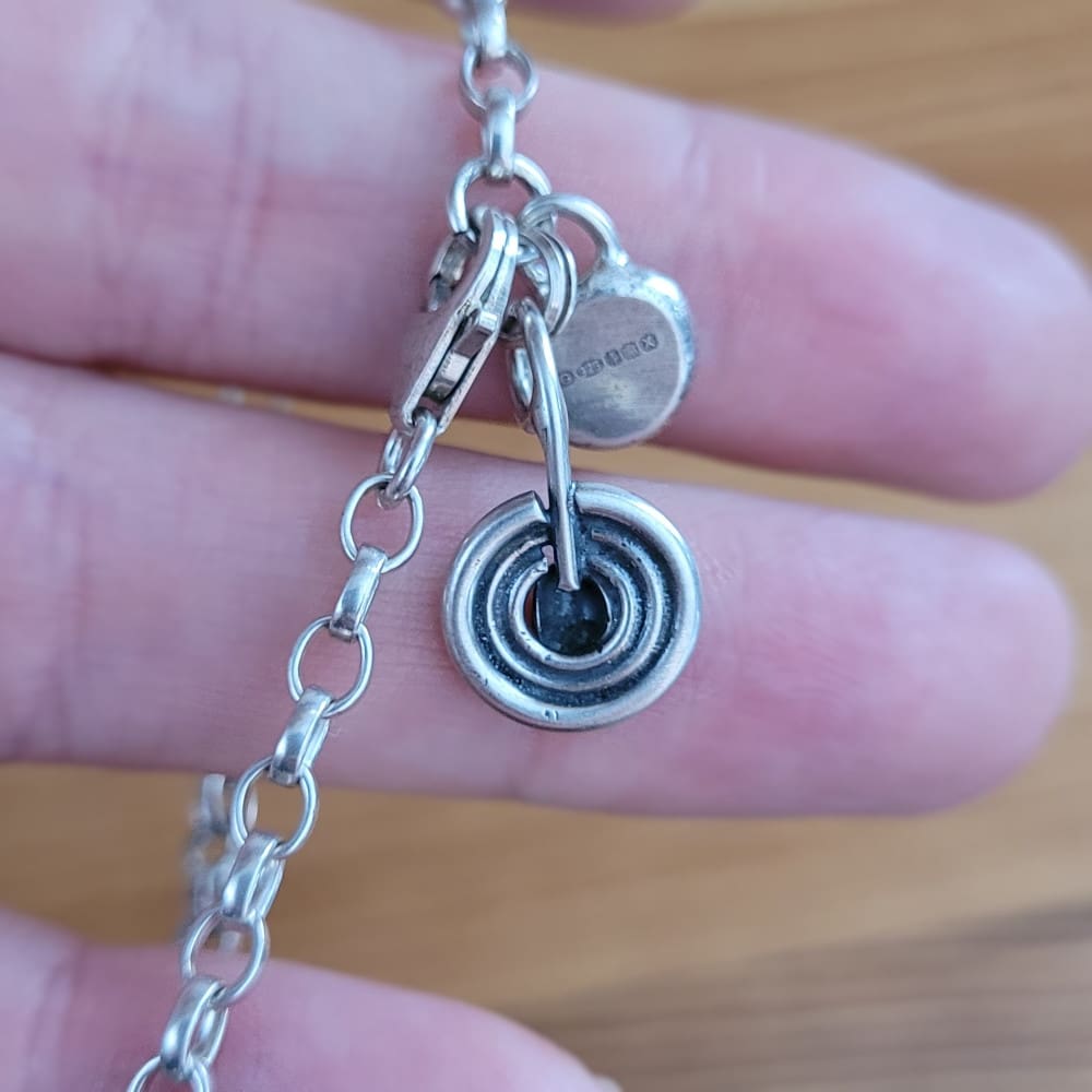 Sterling silver belcher chain bracelet with a charm inspired by ancient rock art known as cup and ring marks.