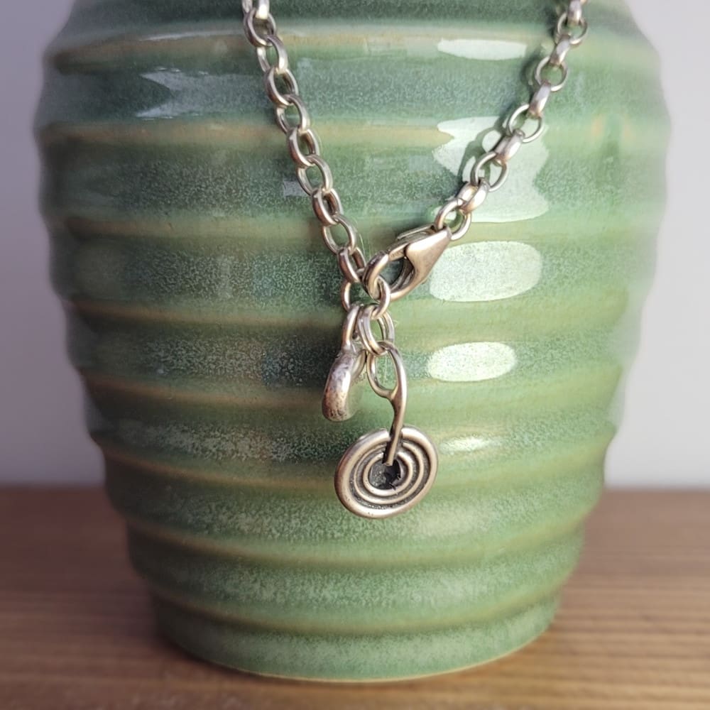 Sterling silver belcher chain bracelet with a charm inspired by ancient rock art known as cup and ring marks.