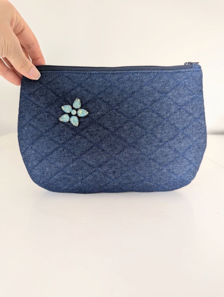 A denim clutch bag, quilted and embellished with turquoise gemstones