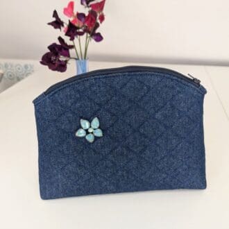 A medium size denim make up pouch with gemstone embellishment