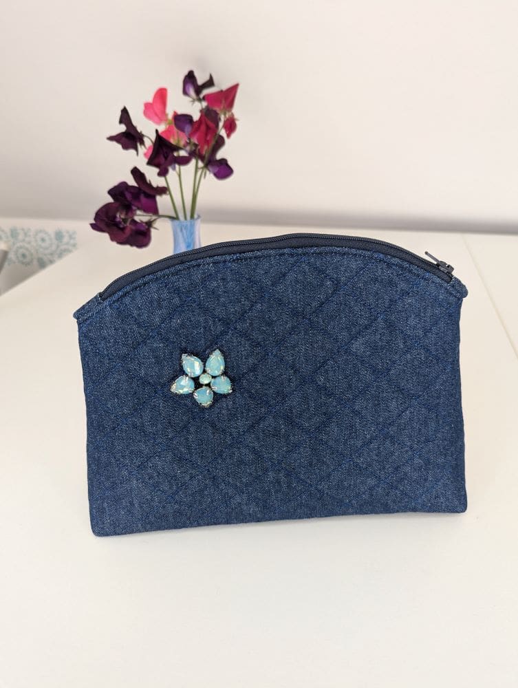 A medium size denim make up pouch with gemstone embellishment