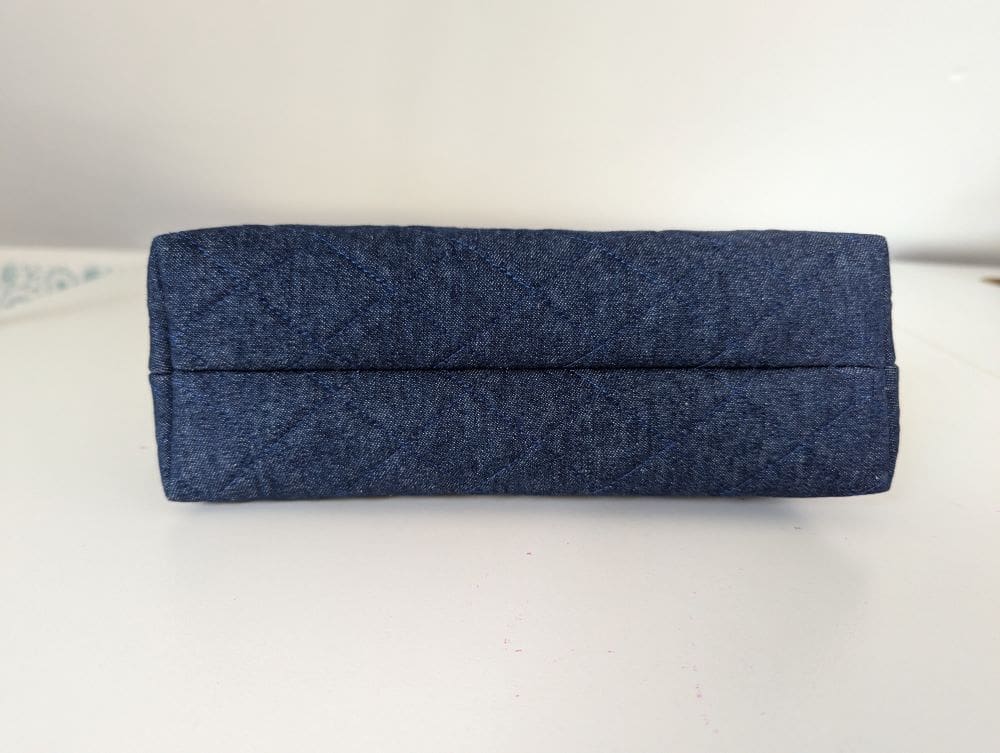 The underside view of a denim make up bag