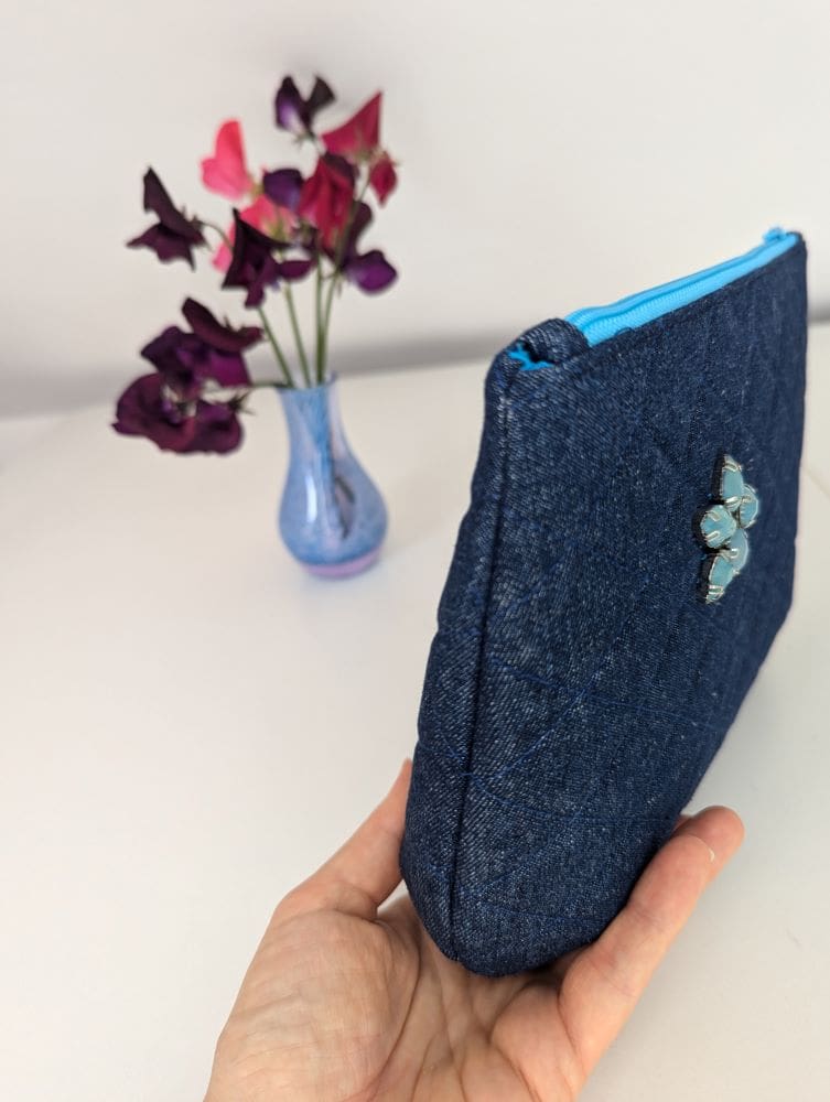 The side view of a handmade denim clutch bag