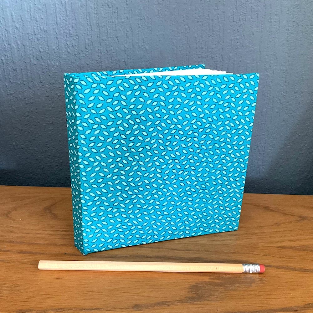 Square shaped handmade sketchbook covered in fabric filled with cartridge paper