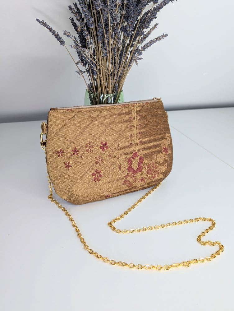 A handmade gold coloured evening bag with a gold coloured copper chain