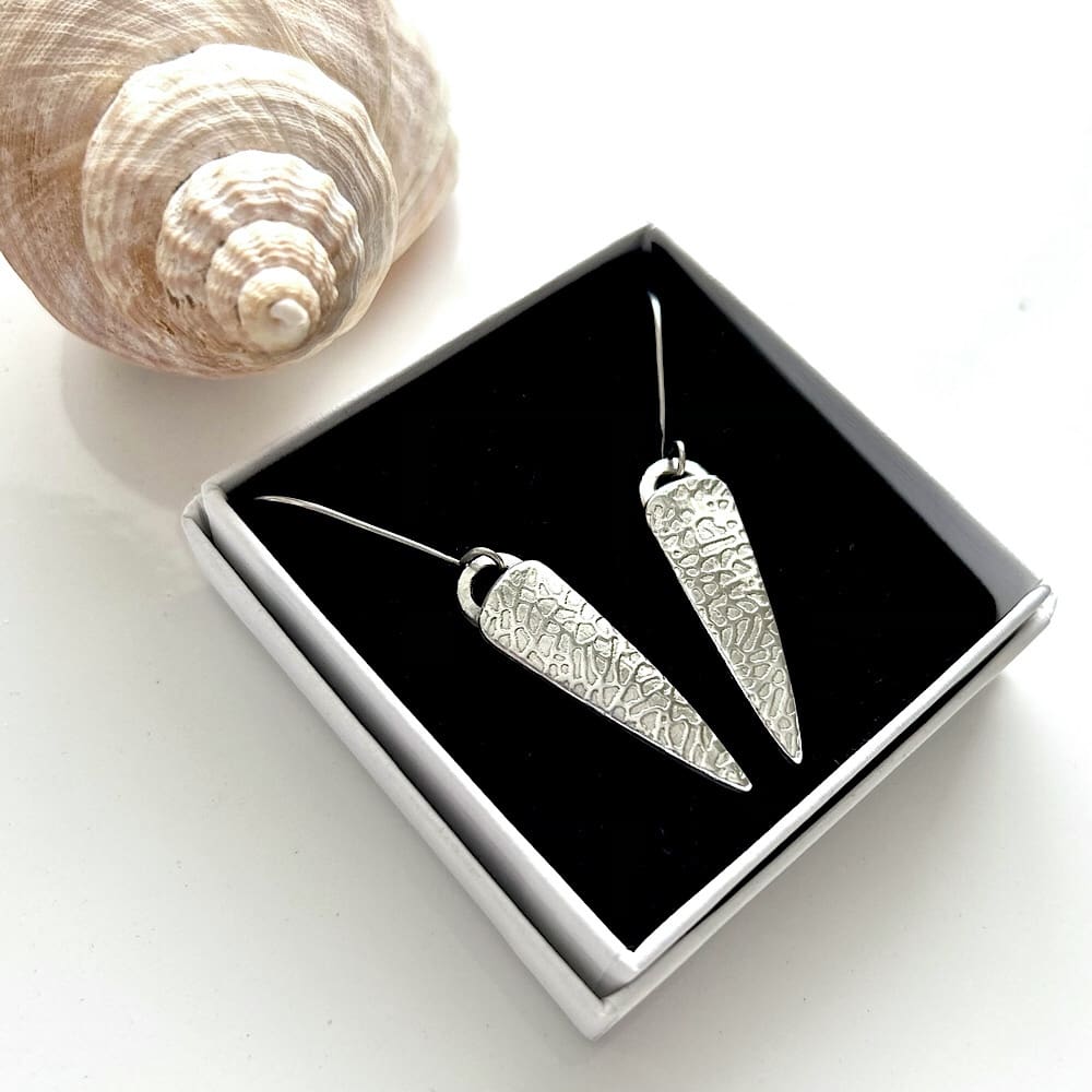 Long drop silver earrings displayed in a small white gift box.