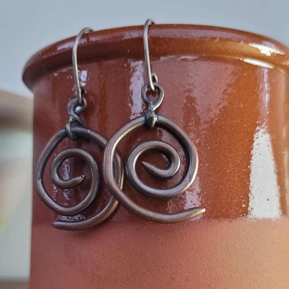 Spiral copper earrings with sterling silver hooks. Part of the Kenaz Collection.