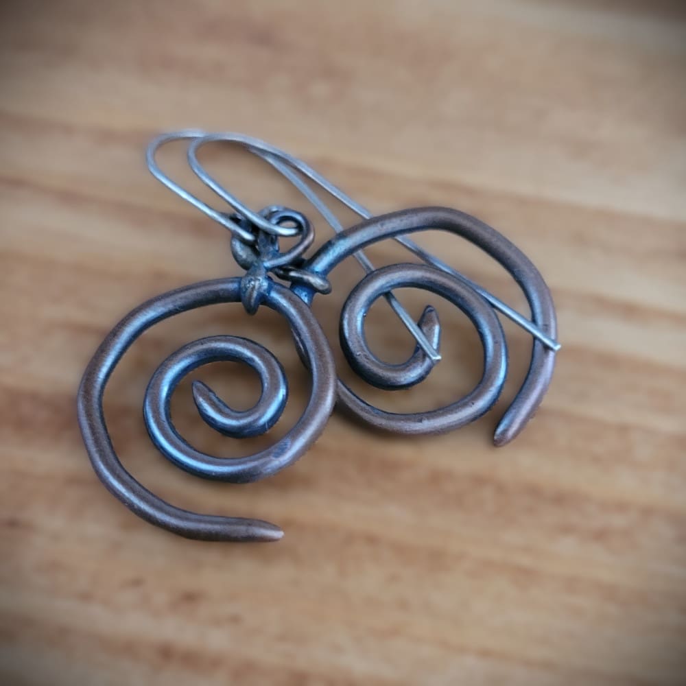 Spiral copper earrings with sterling silver hooks. Part of the Kenaz Collection.