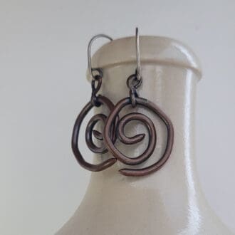 Spiral copper earrings with sterling silver hooks. Part of the Kenaz Collection.