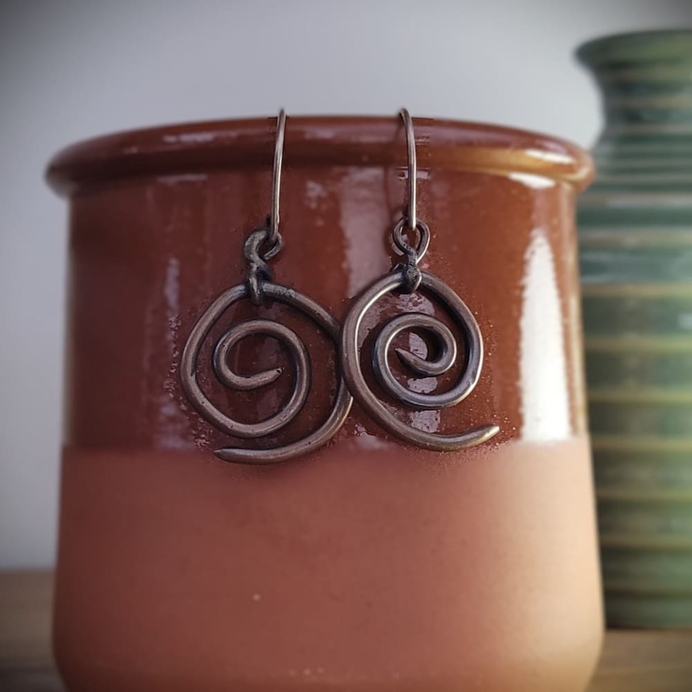 Spiral copper earrings with sterling silver hooks. Part of the Kenaz Collection.