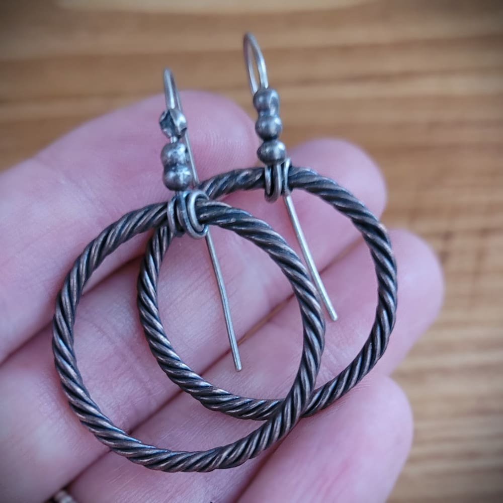 Twisted copper hoop earrings with sterling silver hooks and details in a raw oxidised finish. Part of the Kenaz Collection