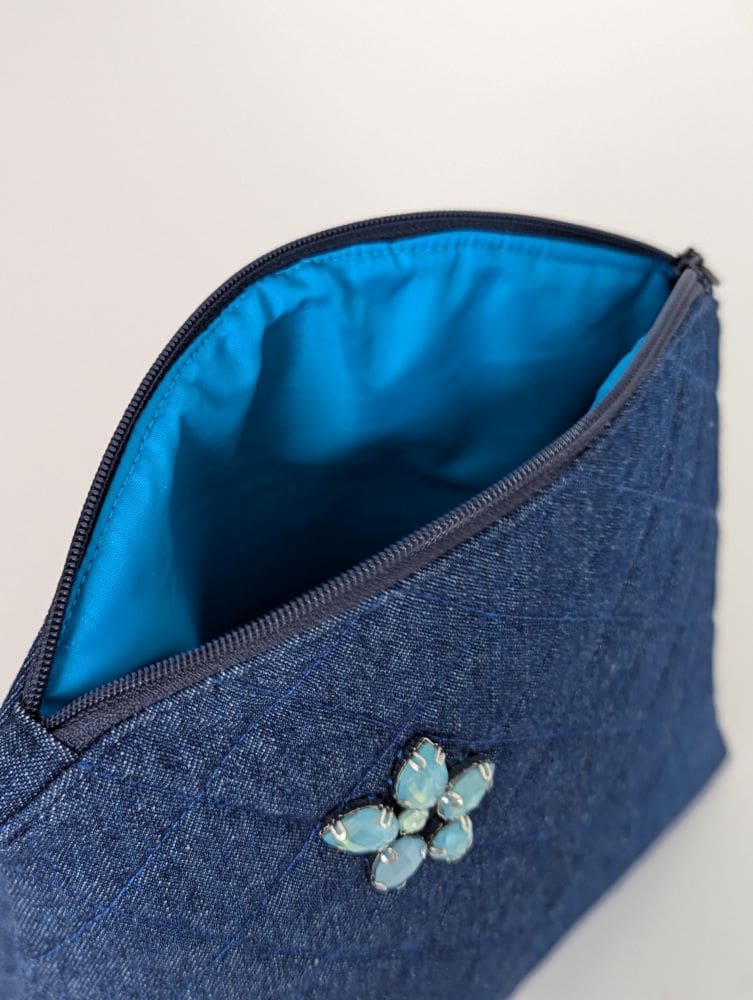 The inside of a quilted denim cosmetics case