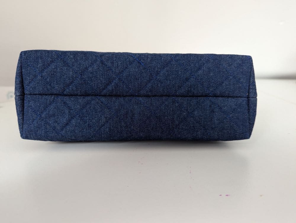 The underside of a blue denim wash bag