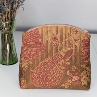 A gold and red cosmetics bag with a peacock design. Quilted. Handmade