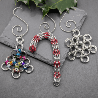 A set of 3 chainmaille Christmas tree decorations. Mase from individual rings linked together in a snowflake, candy cane and Christmas tree shape.