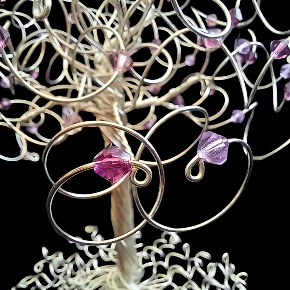 Entwined branches on a silver wire tree with amethyst and violet crystals.