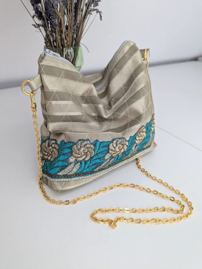 A small, handmade evening bag with a gold chain