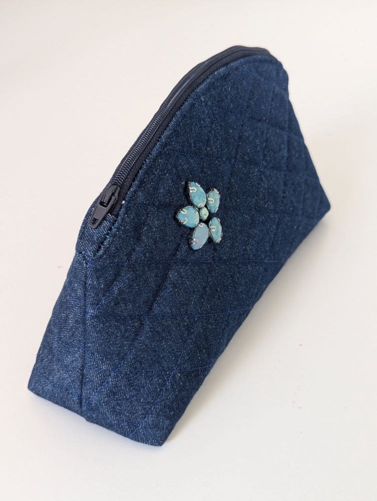 A small denim make up bag made using fabric scraps leftover from dressmaking