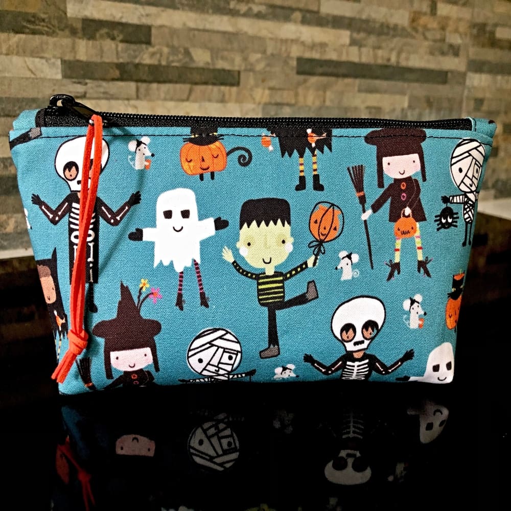 Pencil case or make up bag in blue fabric with cute Halloween figures. A black zip & orange lining.