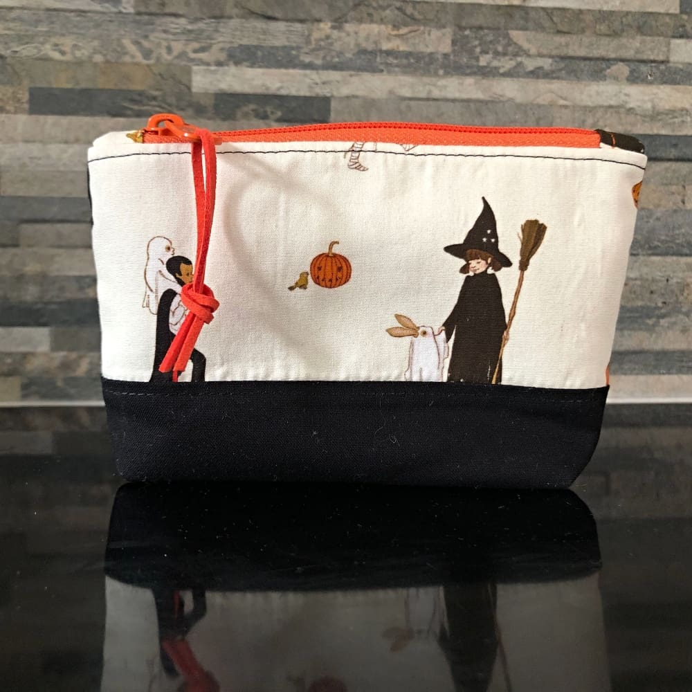 Pencil case or make up bag in fabric with cute Halloween figures. An orange zip & lining.