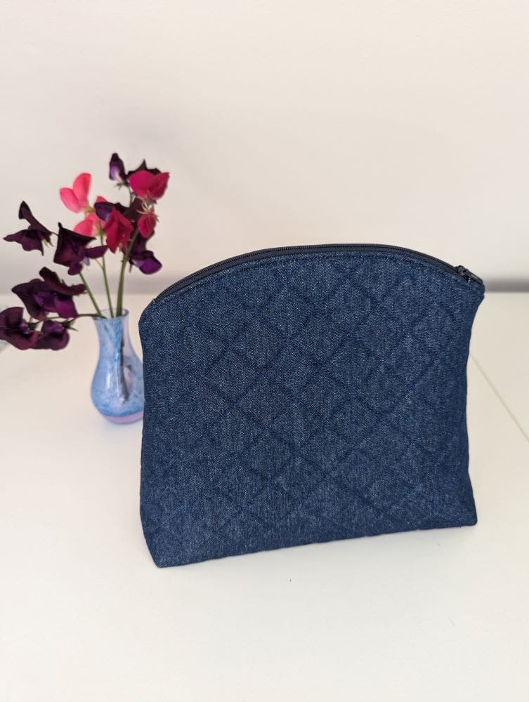 A quilted denim wash bag with zip fastening