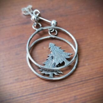 Silver hoop earrings with pine tree.