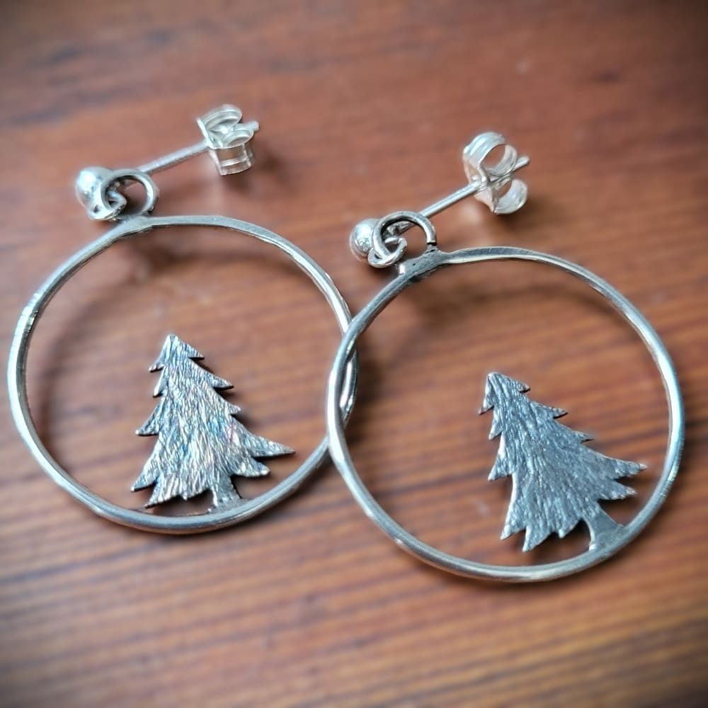 Silver hoop earrings with pine tree.