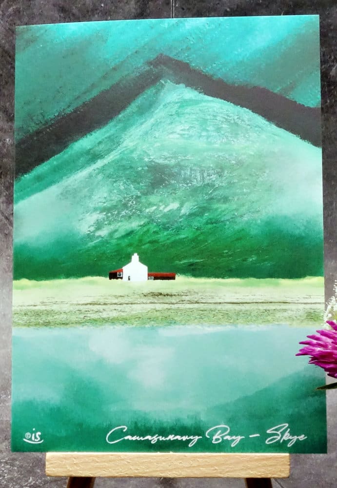 Larger image titled Camasunary Bay showing an A6 size greetings card, blank inside, on a small easel depicting a view of an isolated house with Bla Bheinn in the background on the Isle of Skye.